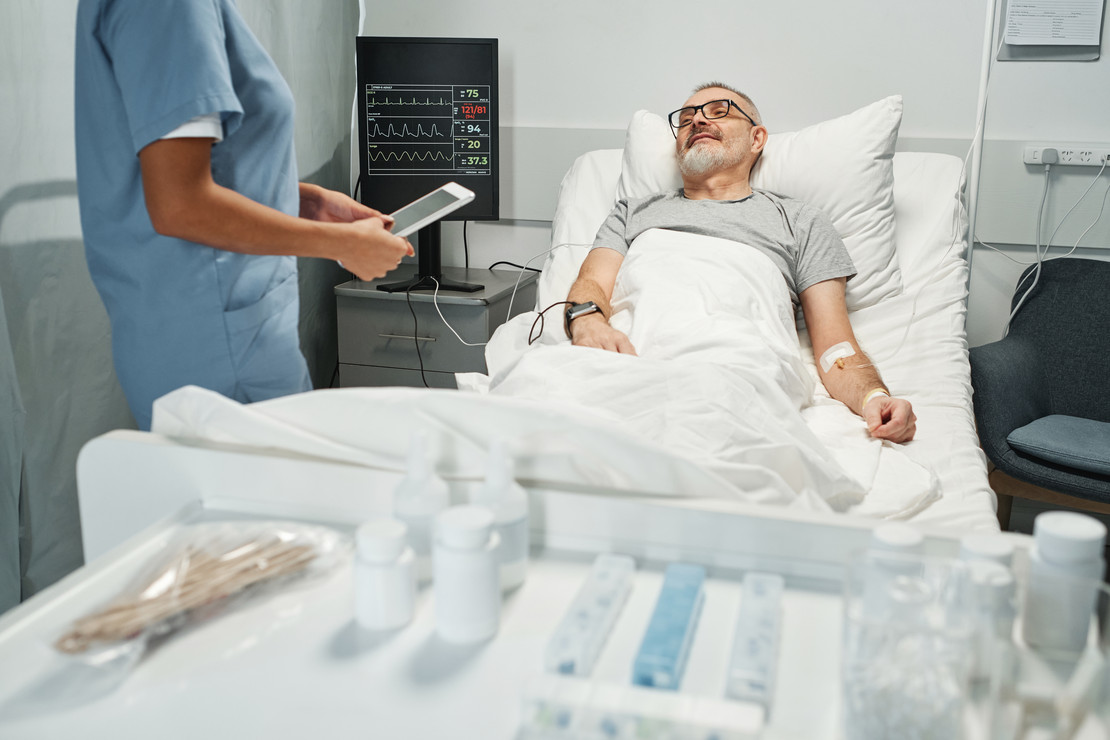 Mann liegt in Krankenhausbett