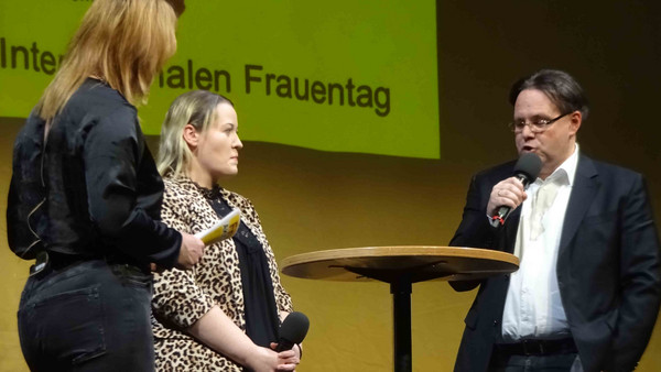 Zwei Frauen und ein Mann reden auf Bühne miteinander