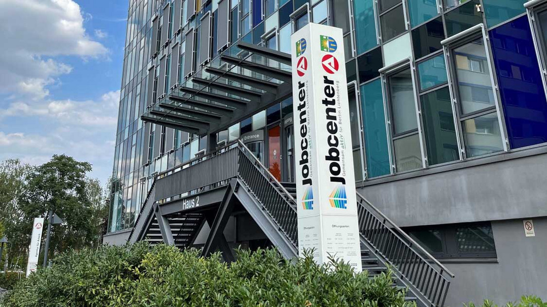 Eingang eines hohen Gebäudes mit Jobcenter-Logo