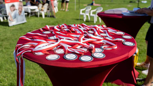 Tisch voller "Finisher"-Medaillen mit rotem Umhängeband. 