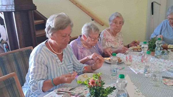 Drei Frauen sitzen am Tisch und essen.