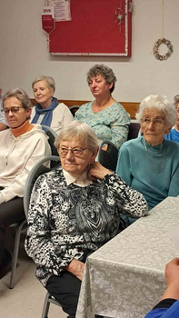 Frauen am Tisch hören zu.