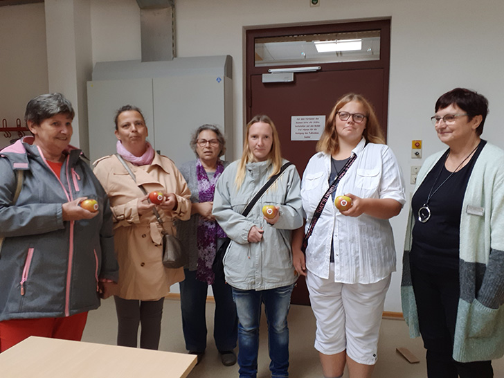 die Frauen des SoVD-Landesausschusses den Besucher*innen mit SoVD-Äpfeln als Geschenk.