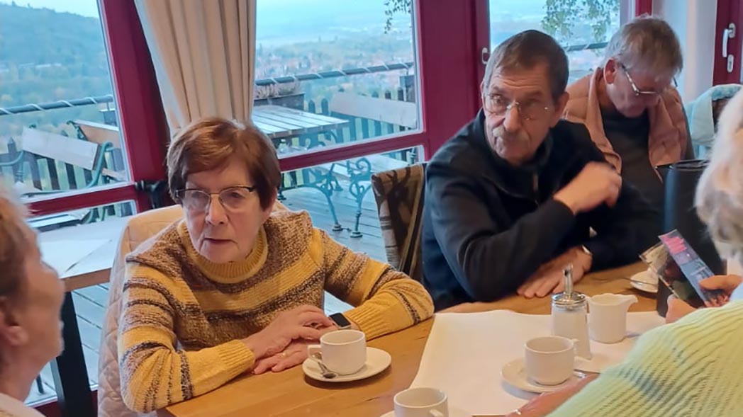 Drei Leute sitzen am tisch und reden.